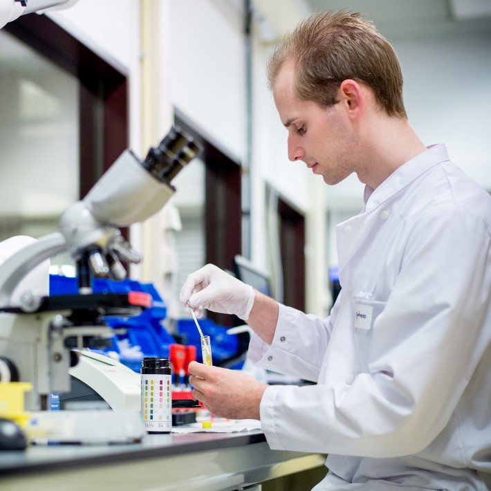 Onderzoeker in lab met microscoop